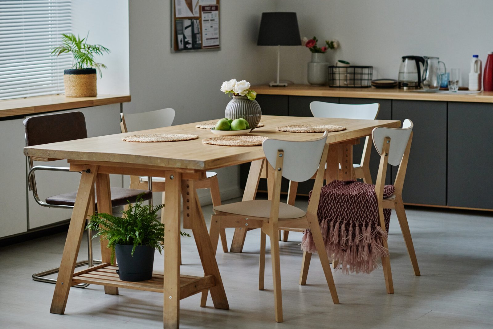 Horizontal image of modern kitchen with wooden dining table in the centre of the room